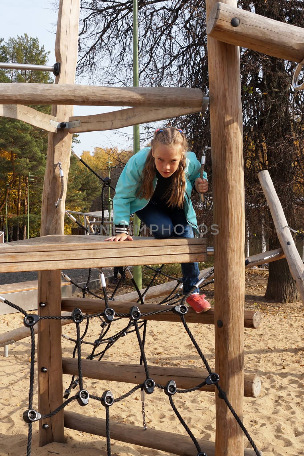 child girl climbing rope playground in the park.