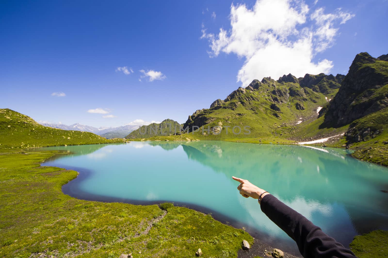 Alpine mountain lake landscape and view, blue beautiful and amazing lake panorama, wide angle lens landscape and mountain reflections in Okhrotskhali in Svaneti, Georgia.