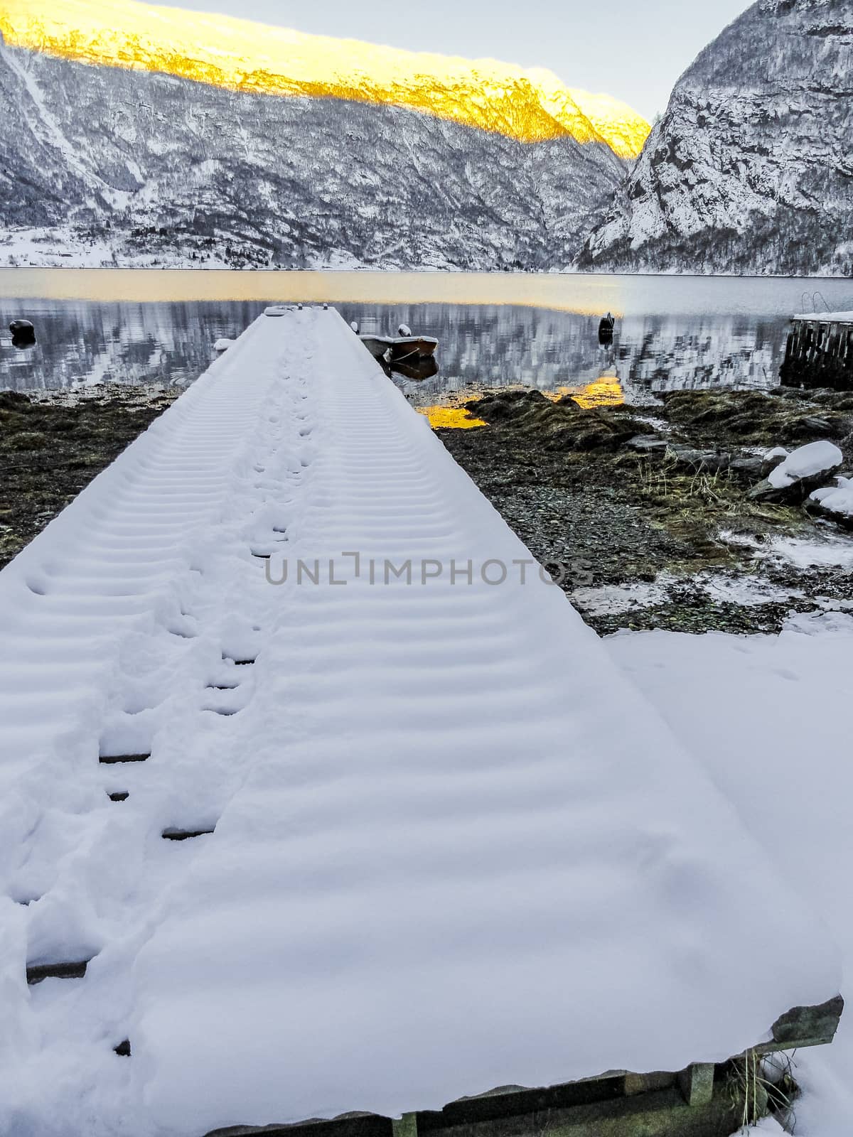 Snow-covered jetty winter landscape at the fjord lake Norway. by Arkadij