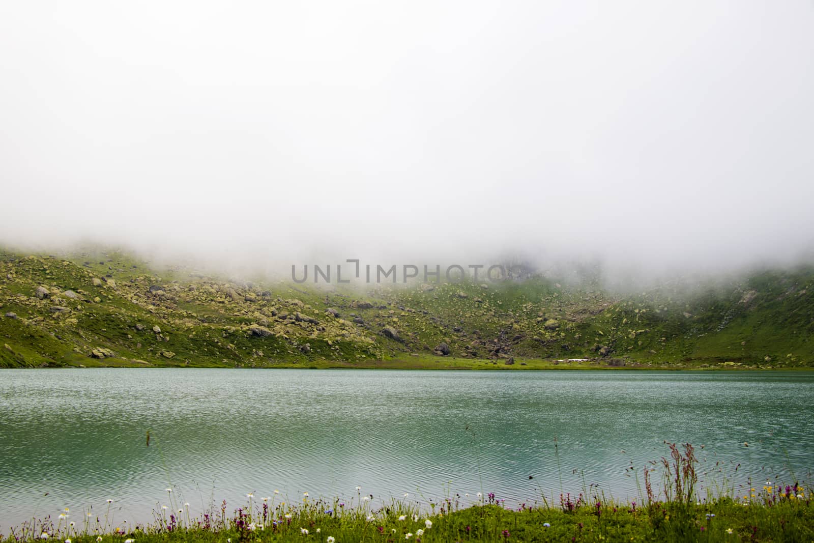 Mountain lake and fog, misty lake, amazing landscape and view of alpine lake Okhrotskhali in the Svaneti by Taidundua