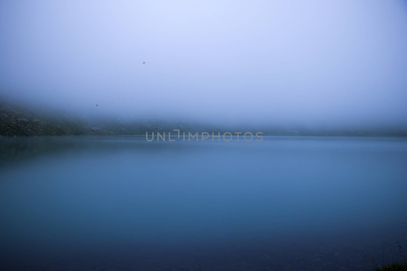 Mountain lake and fog, misty lake, amazing landscape and view of alpine lake Okhrotskhali in the Svaneti by Taidundua