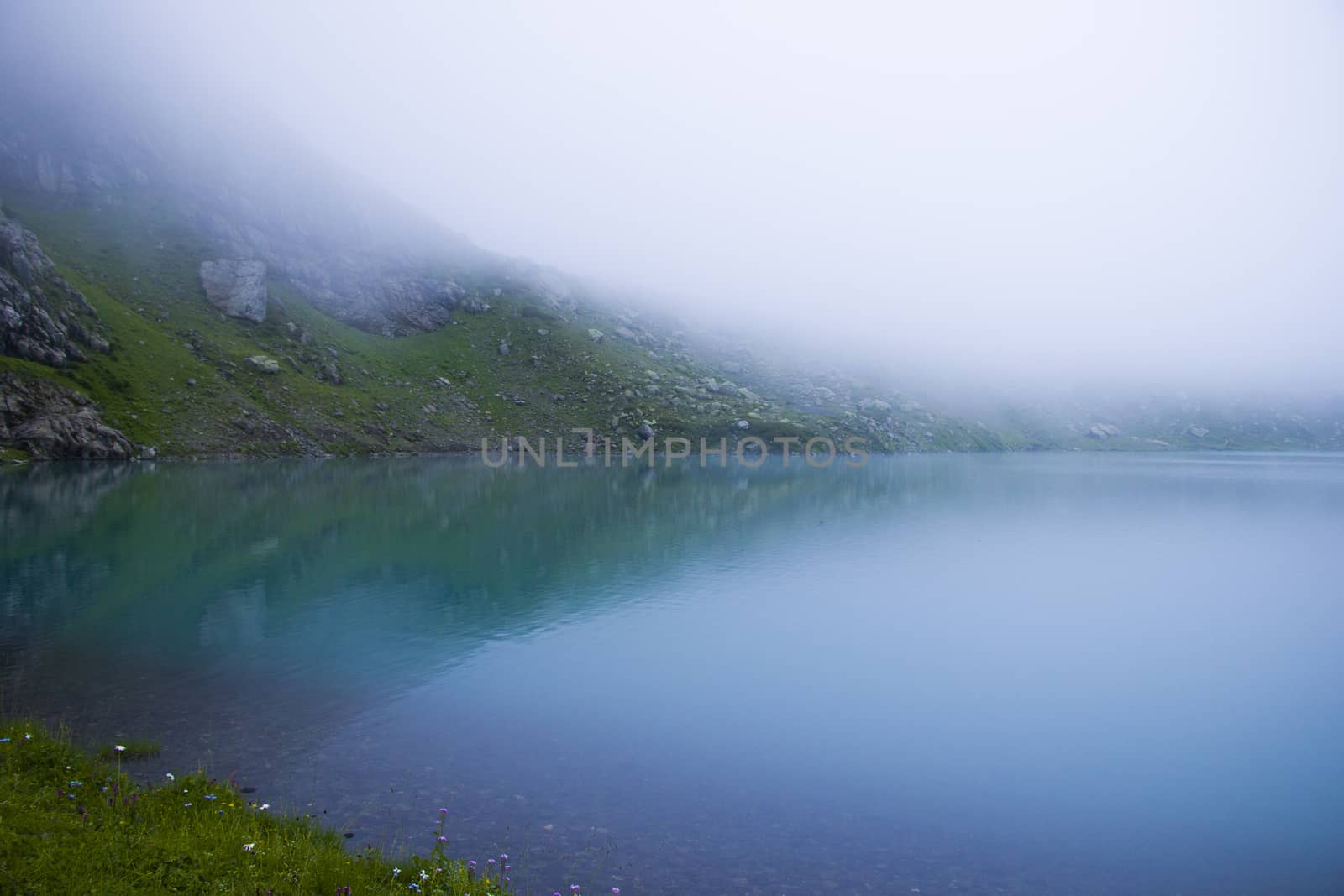 Mountain lake and fog, misty lake, amazing landscape and view of alpine lake Okhrotskhali in the Svaneti by Taidundua