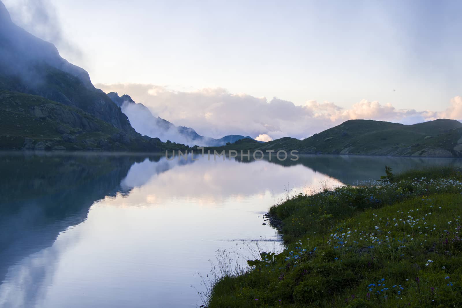 Mountain lake and fog, misty lake, amazing landscape and view of alpine lake Okhrotskhali in the Svaneti by Taidundua