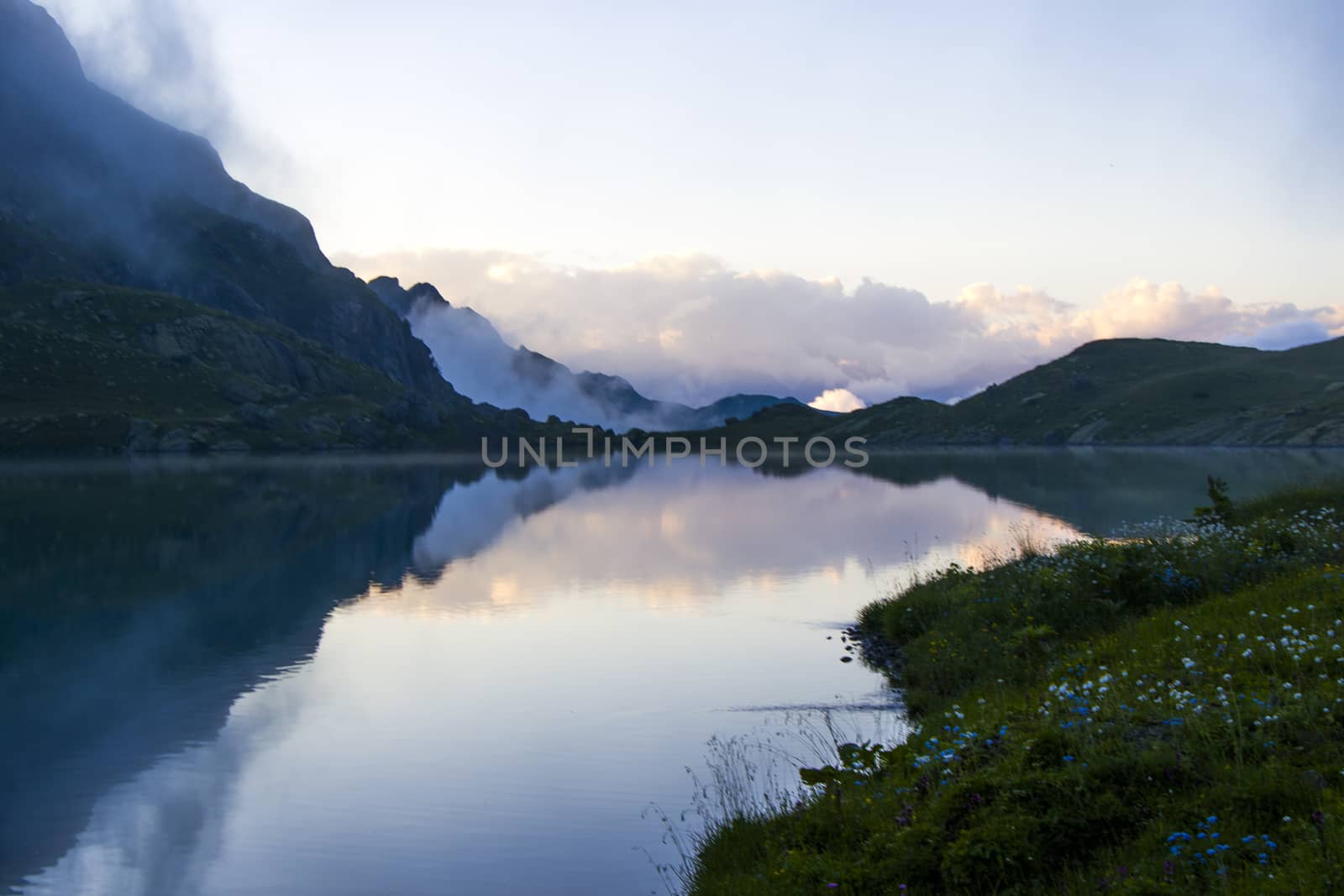 Mountain lake and fog, misty lake, amazing landscape and view of alpine lake Okhrotskhali in the Svaneti, Georgia