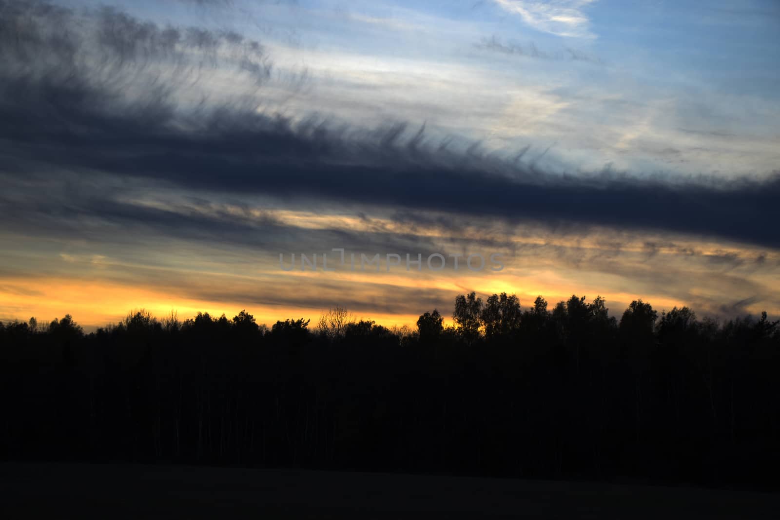 Sunset colored sky, blue, yellow, orange and red, mixed colors,shadows and lights, in Europe