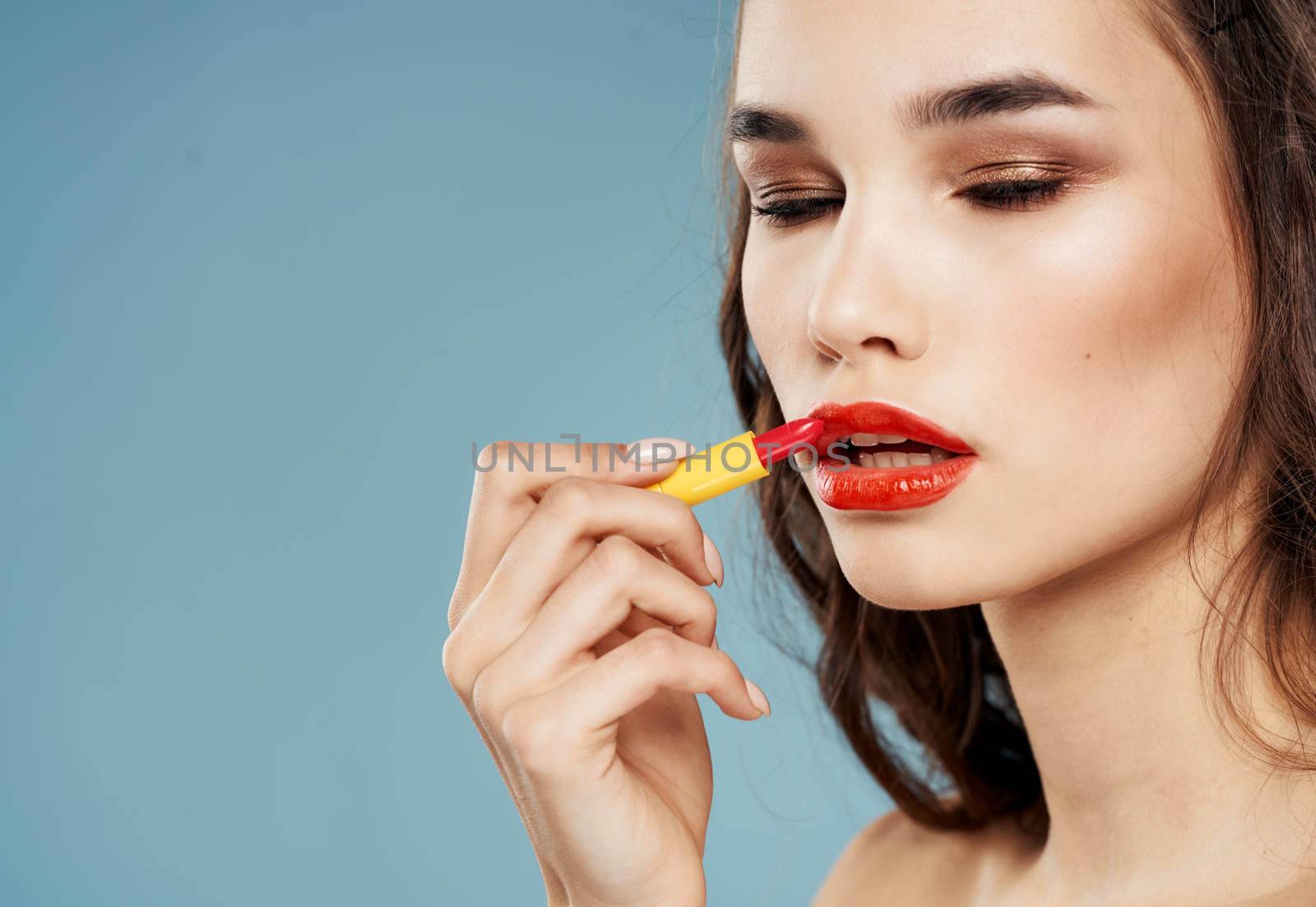Sexy brunette with bright makeup and lipstick blue background by SHOTPRIME