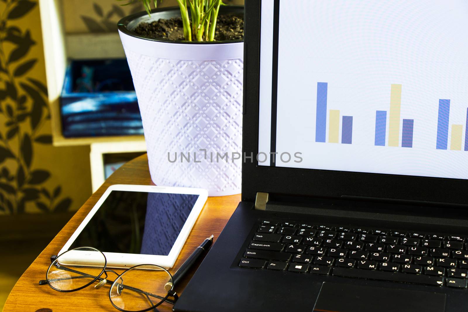 Workspace at home, notebook, mobile device, coffee and plants on the table, laptop desktop