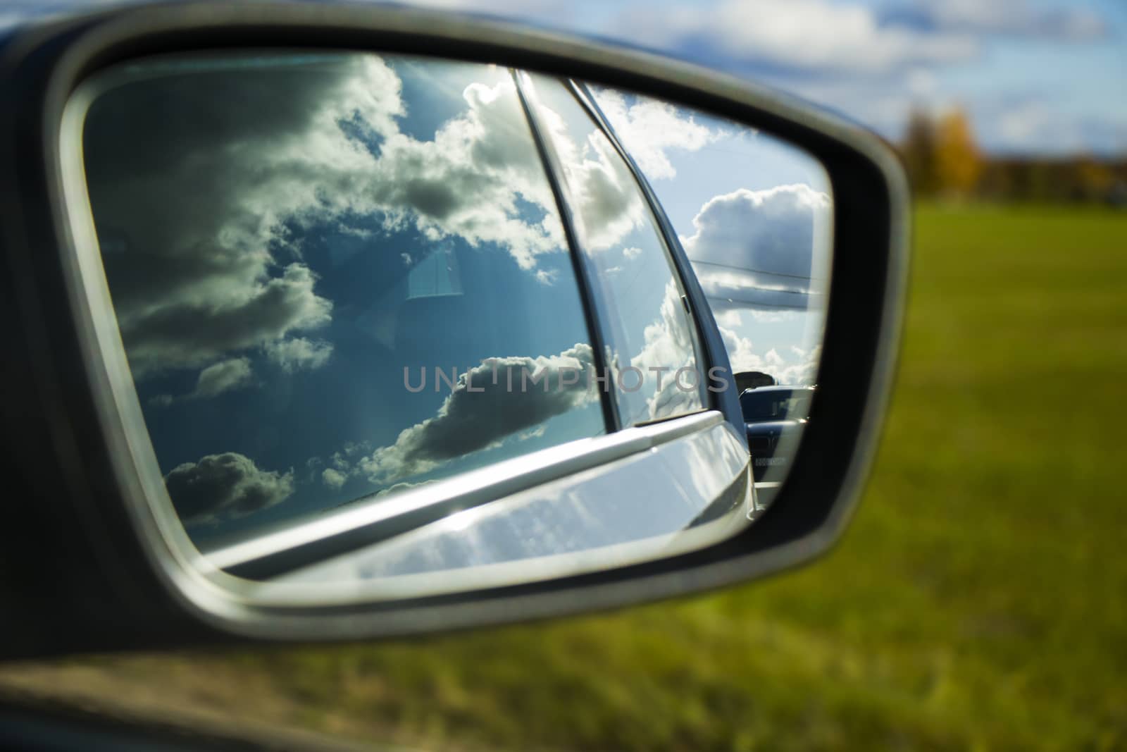 View in the car mirror.Highway, autobahn and road landscape. Automobile, cars and vehicles. Blue sky and sunny day. European autobahn. Nature and urban together.