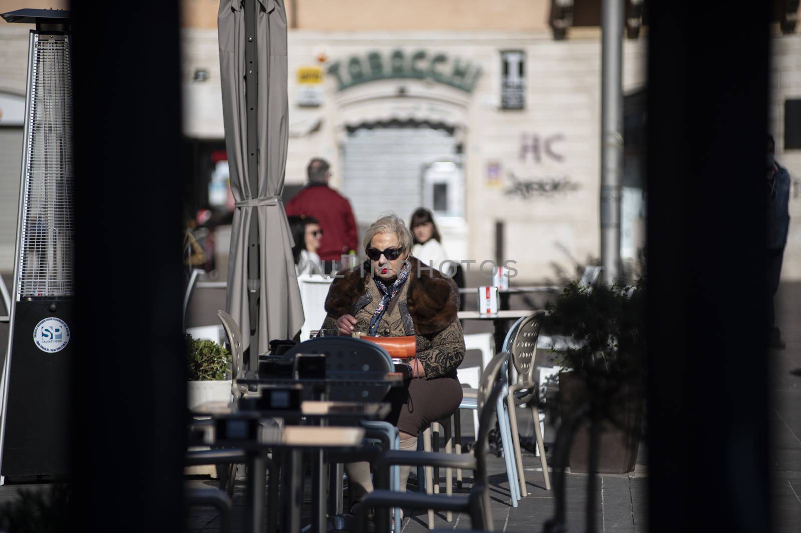terni,italy october 21 2020:woman sitting at a table in an outdoor cafe