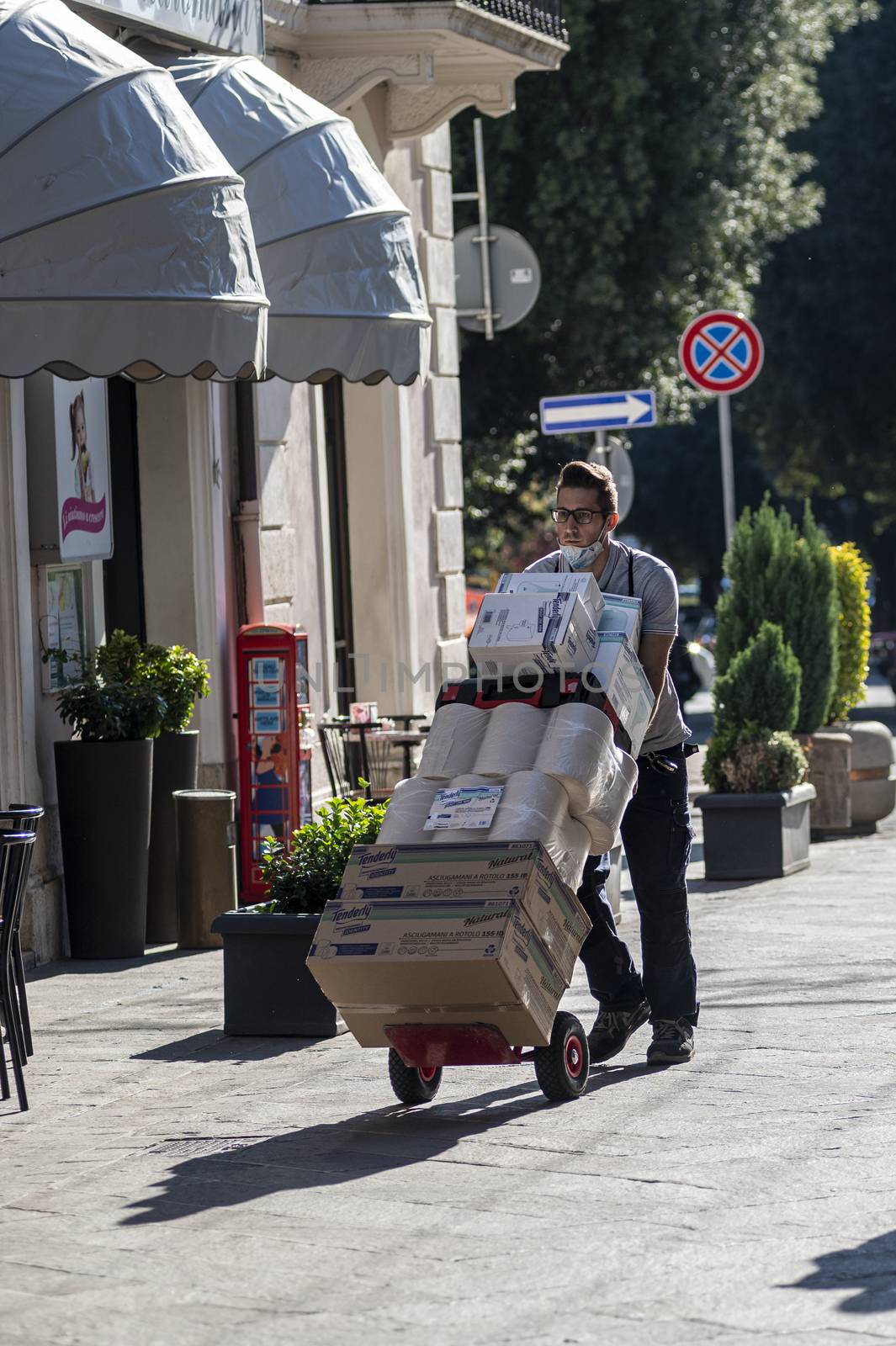 terni,italy october 21 2020:courier carrying packages in a shop