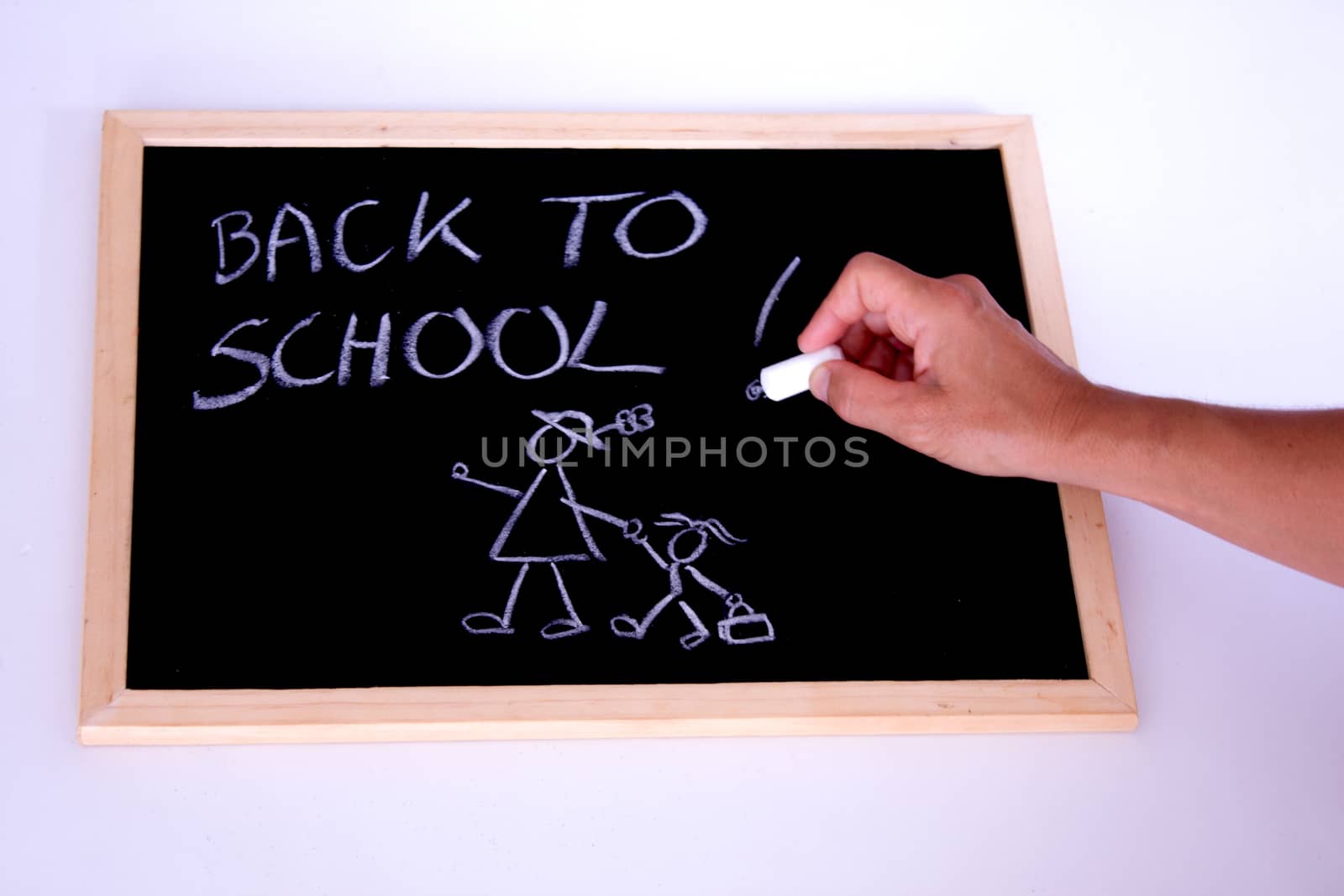 A hand writting back to school with a chalk