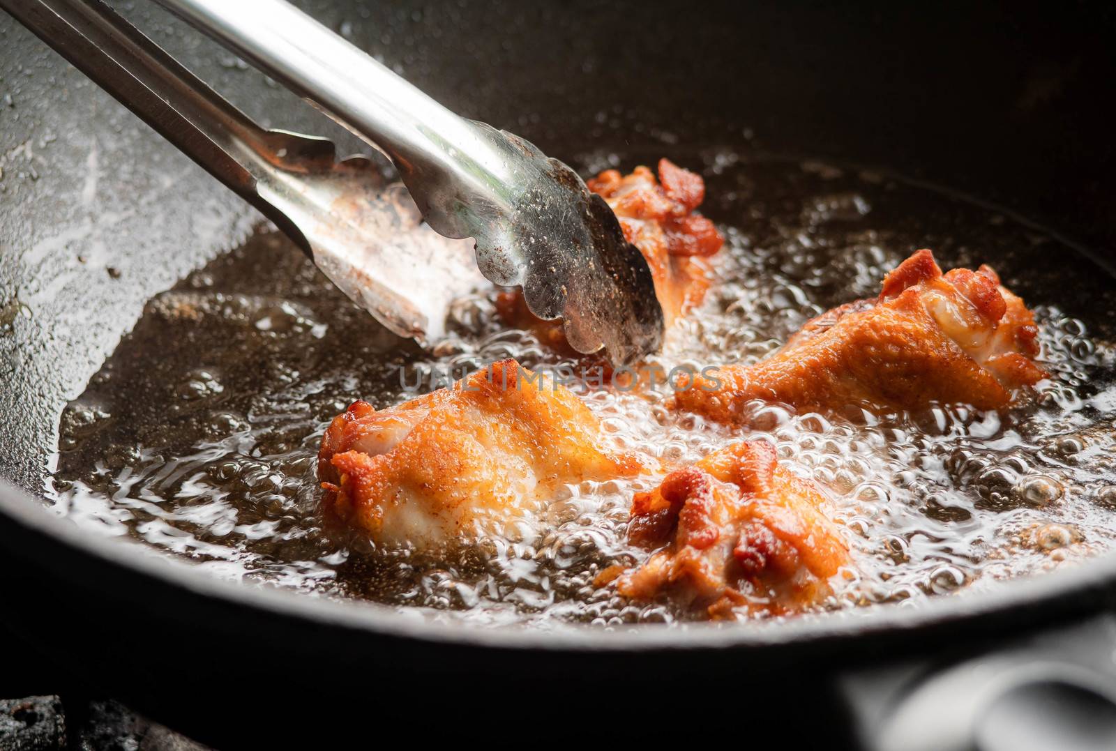 Chicken drumsticks fried in boiling oil. Thai street food.