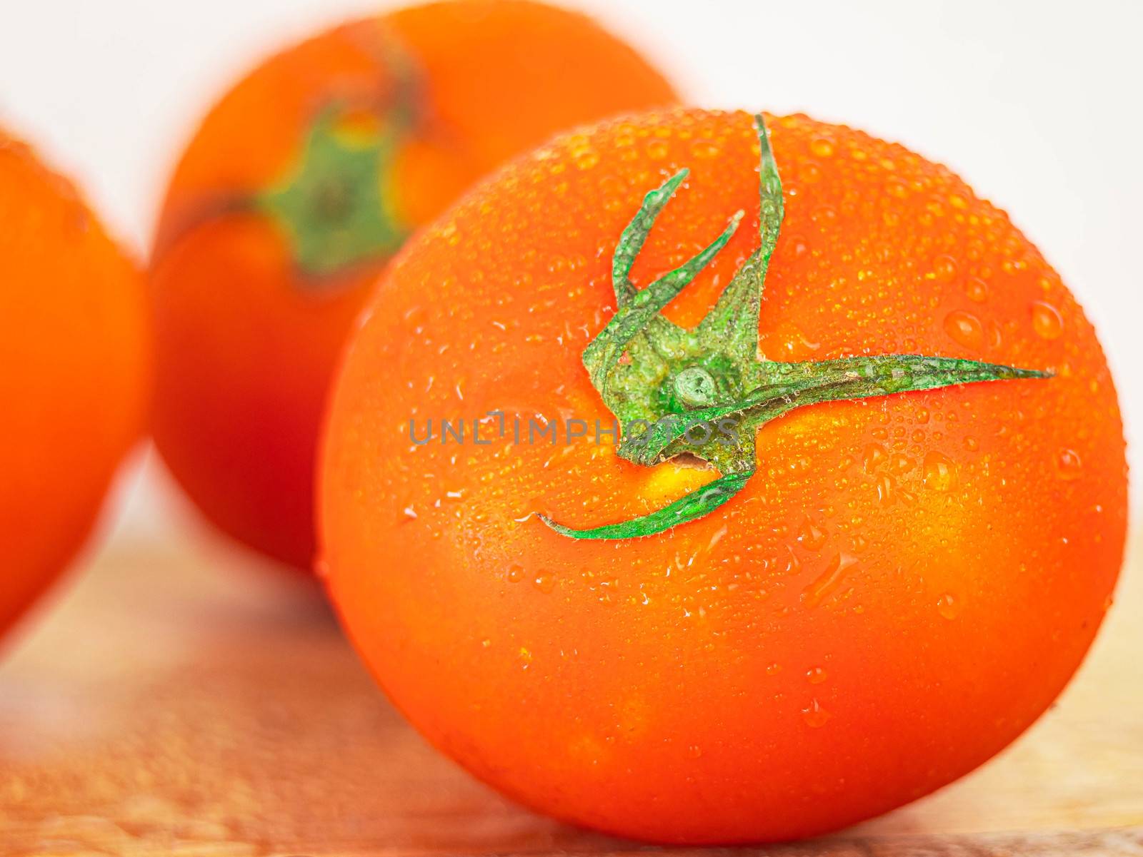 Red ripe tomatoes with water spray to freshness after harvesting on wooden background.