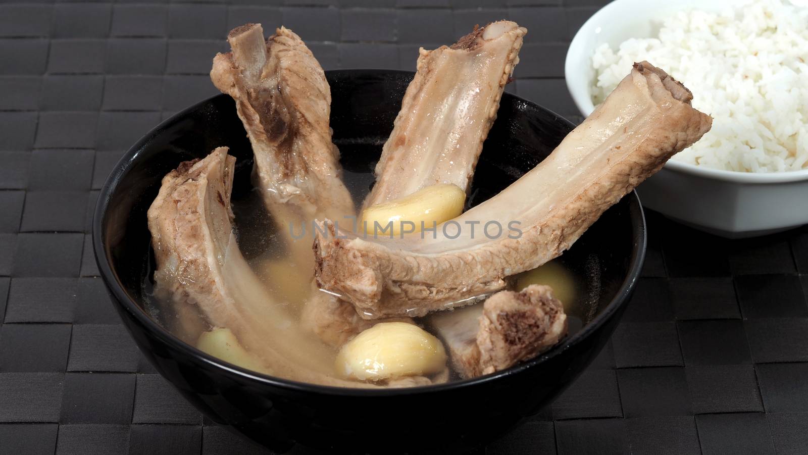 Bak kut teh or pork ribs soup which made from many ingredients such as big garlic, white pepper and many spices. Very popular traditional authentic menu dish in Singapore and Malaysia. Served hot with rice bowl
