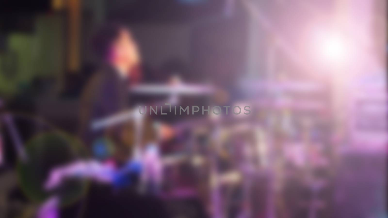 Blurry image of musician performing live show concert on the stage with professional equipment.