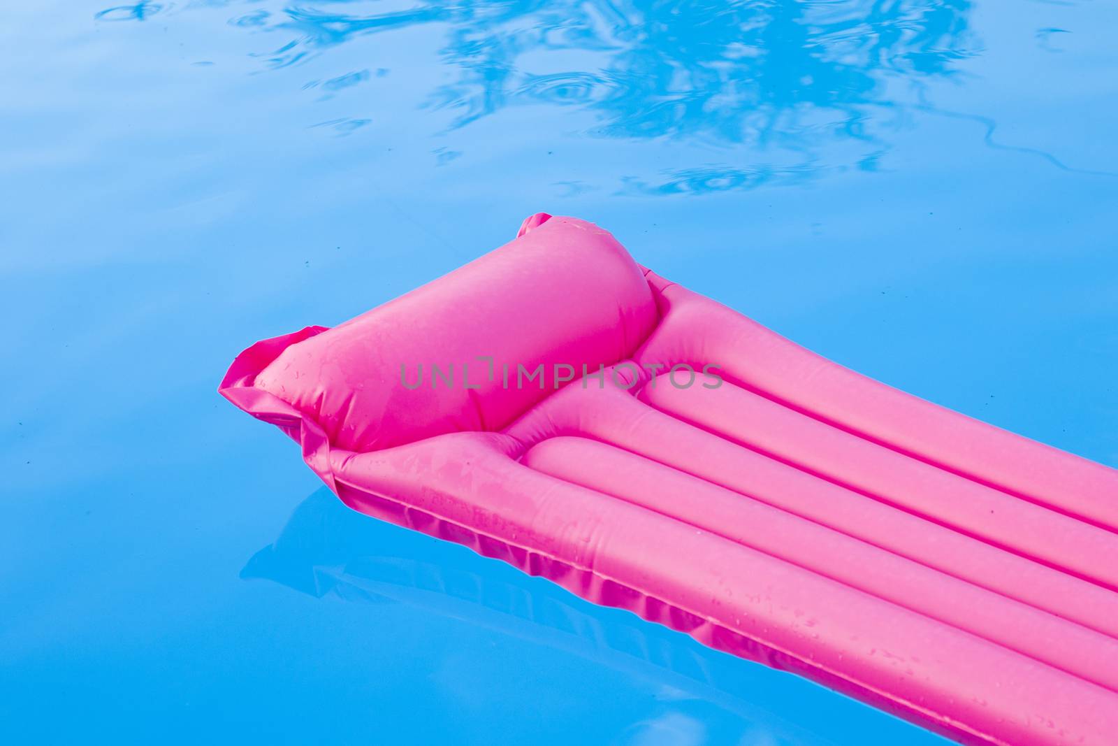 Swimming pool and pink mattress, summertime and empty pool, vacation and holiday, water background. Colorful summer background.