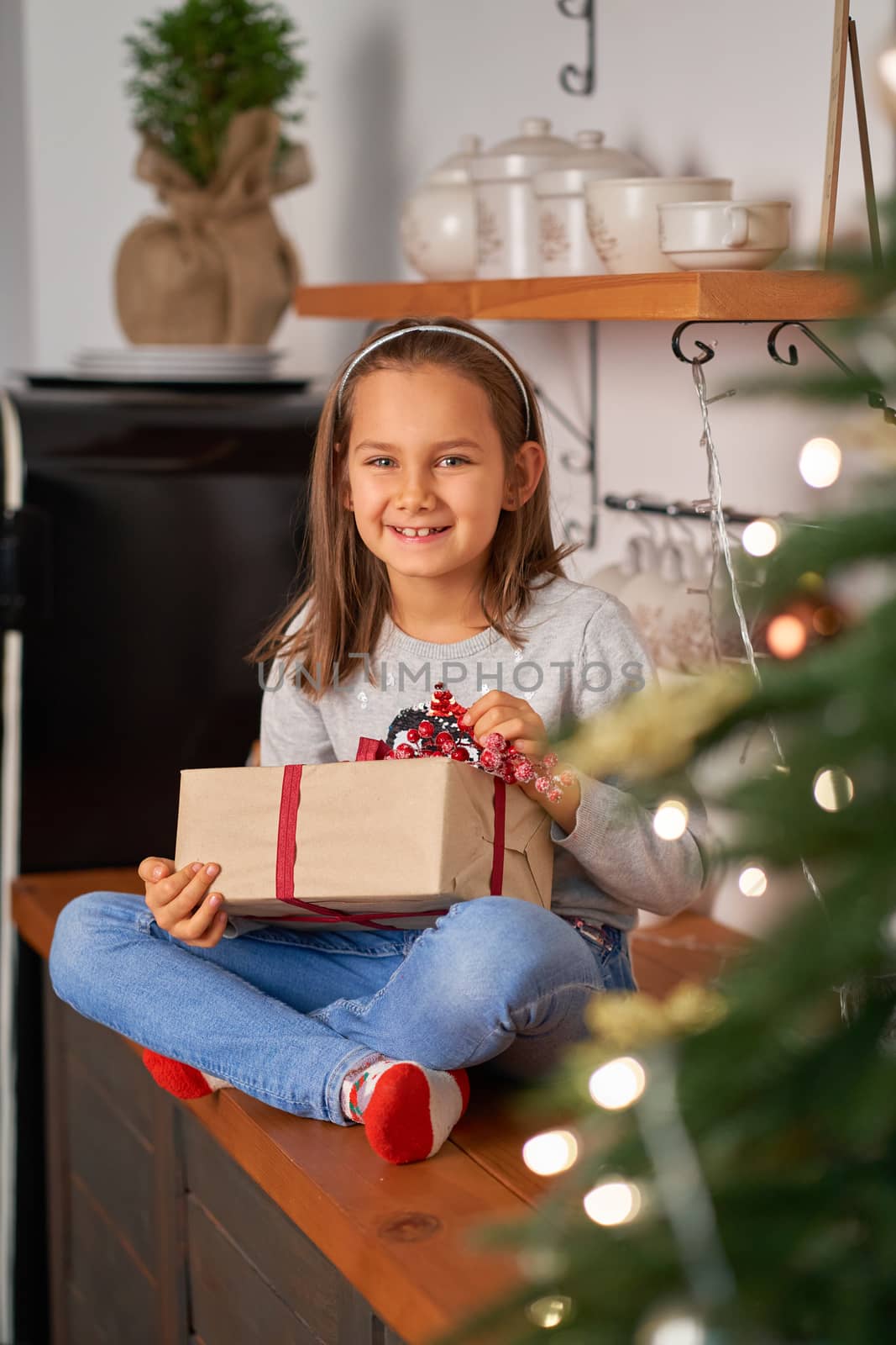 Little girl opens a box with a Christmas present from Santa.