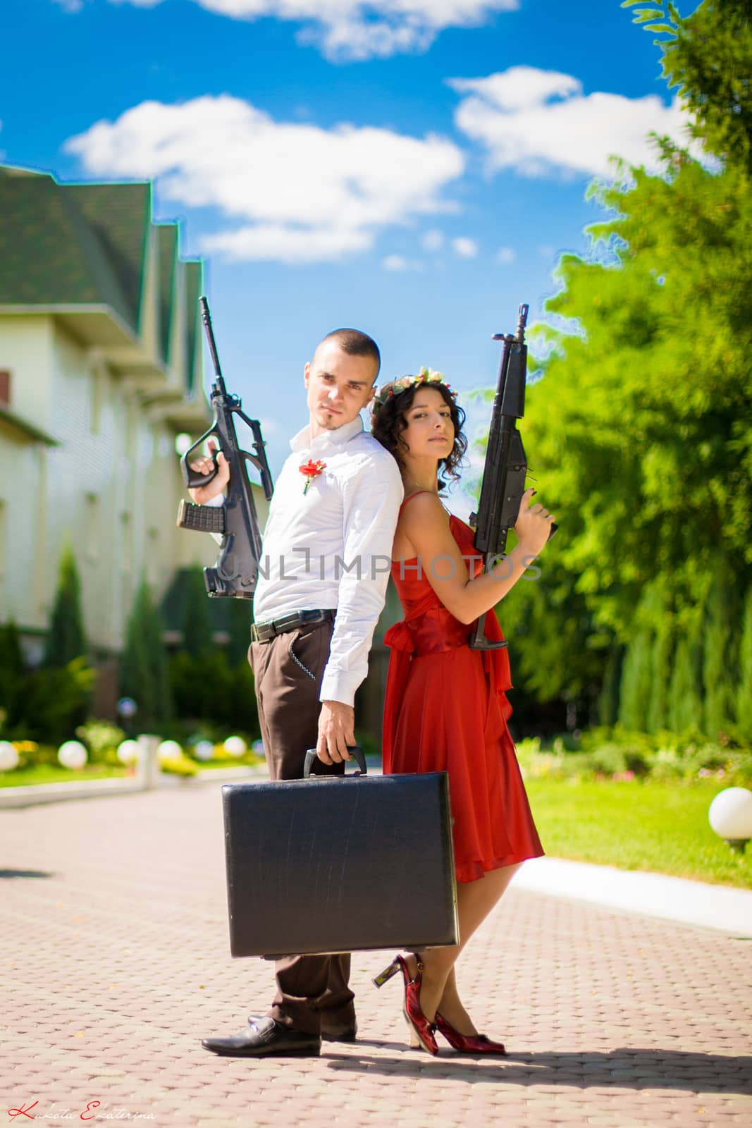 Young couple of criminals with weapons and a suitcase full of money by Try_my_best