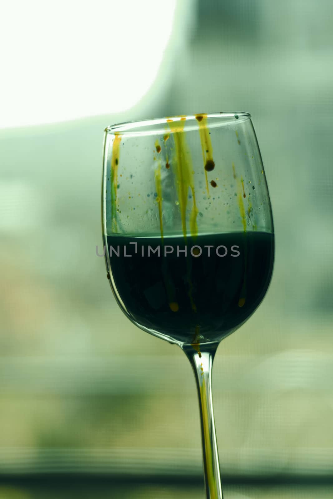 Paint in wineglass, red and blue colors water, art photo.
