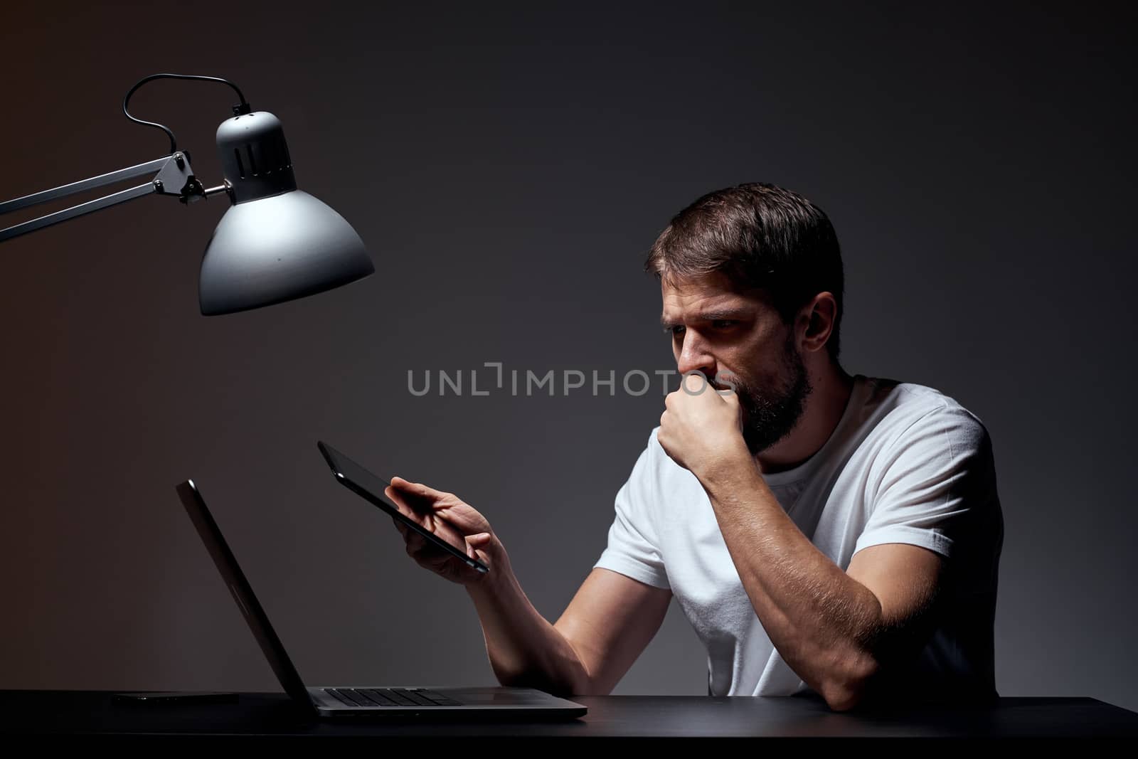man with laptop sitting at table dark background workplace office emotions lamp gesturing with hands model cropped view by SHOTPRIME