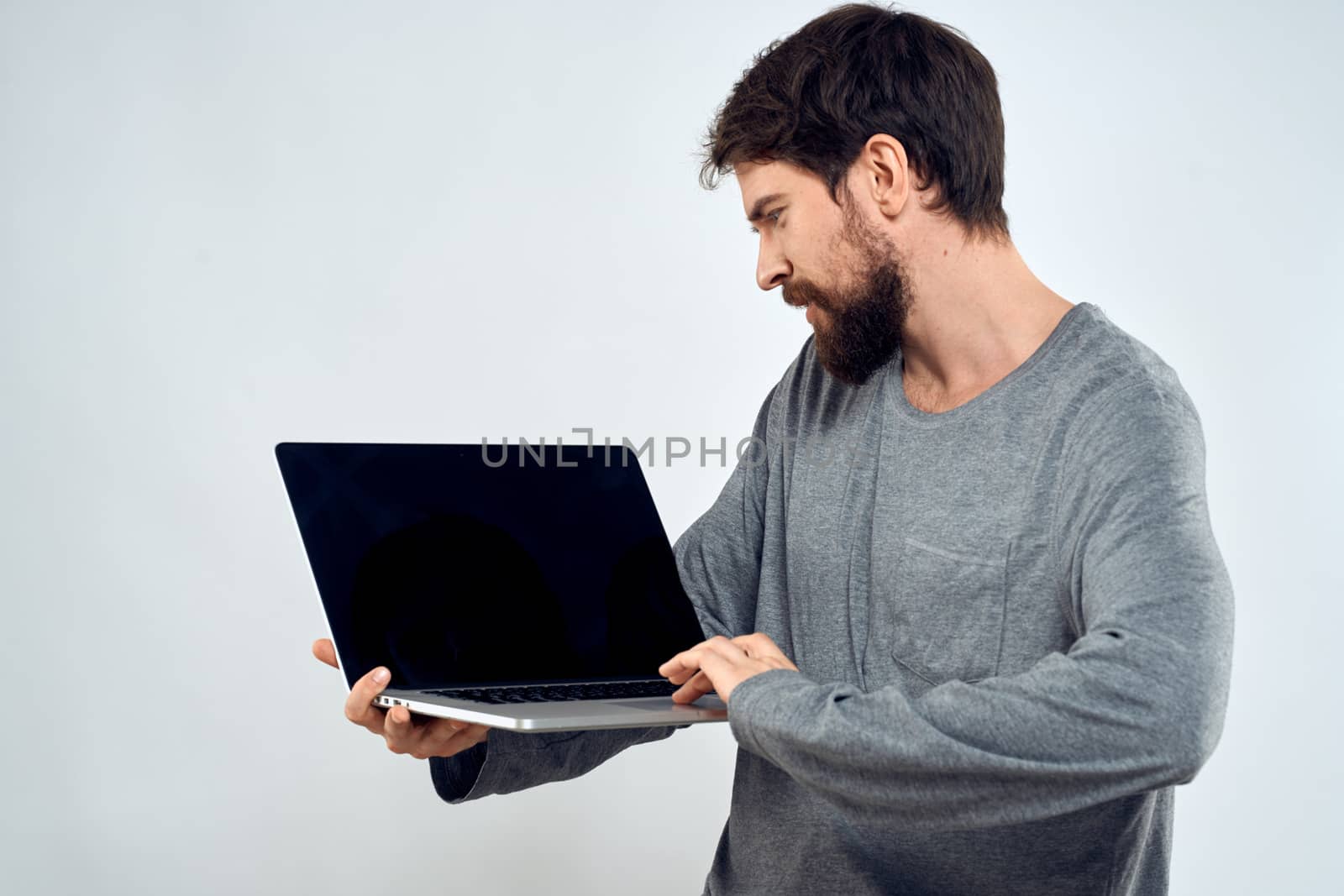 A man in a gray sweater with a laptop hands lifestyle technology communication internet work. High quality photo