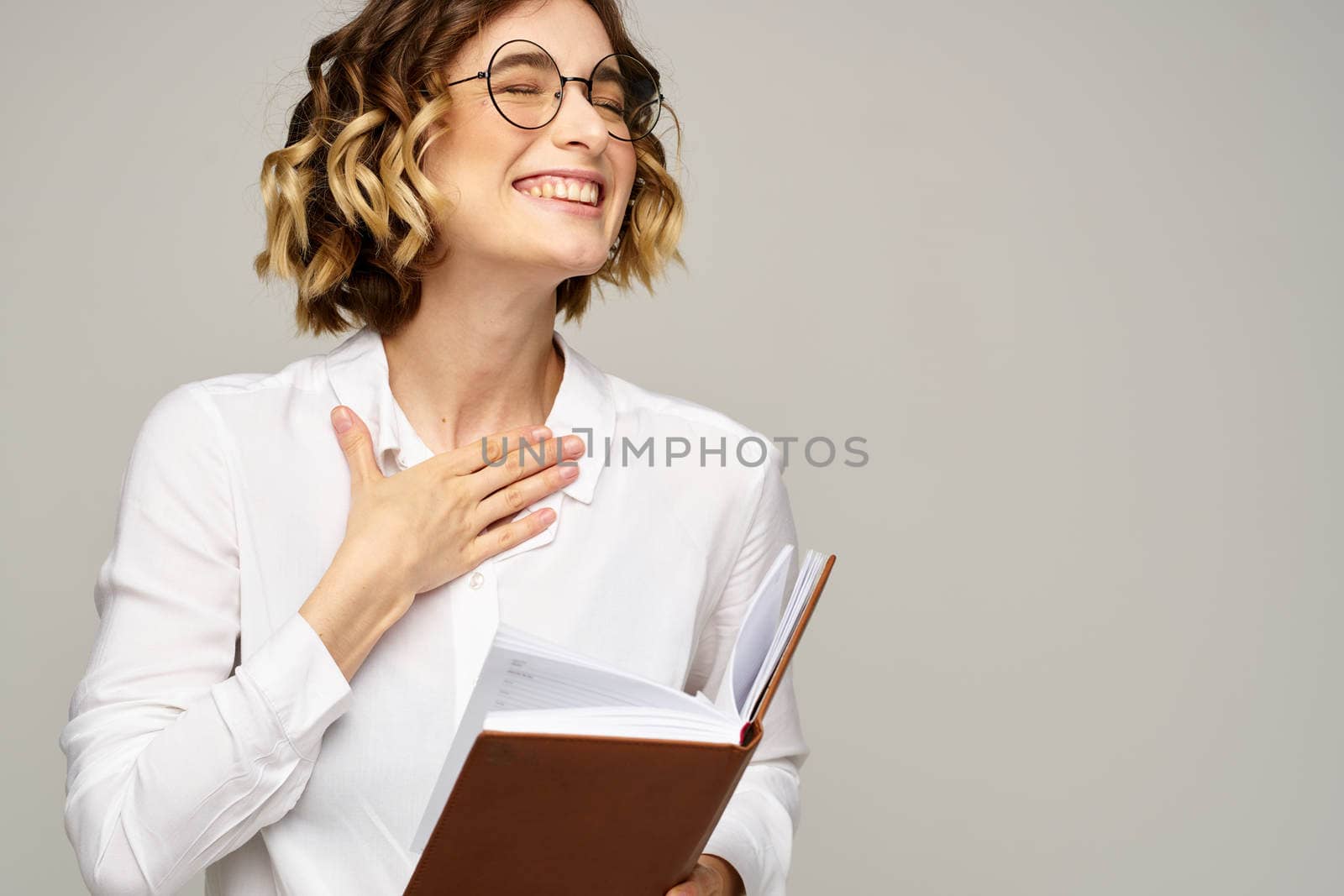 woman with notepad in hands business work beige background glasses hairstyle. High quality photo