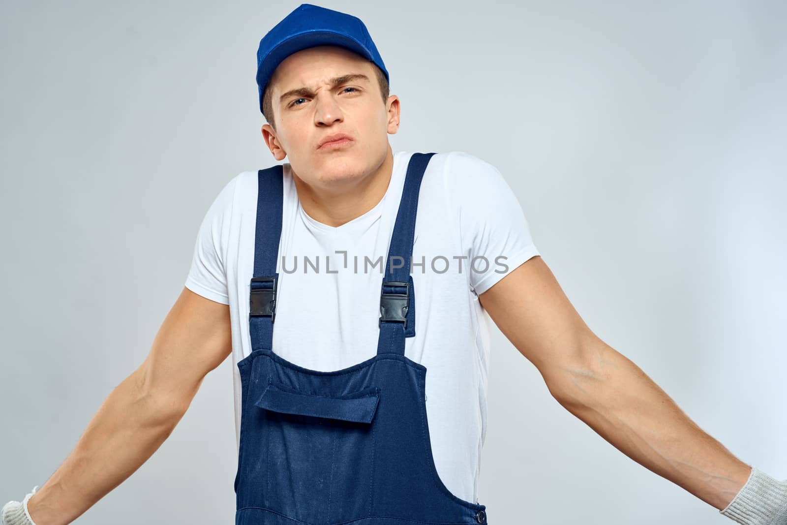 Man worker in forklift uniform delivery service light background. High quality photo