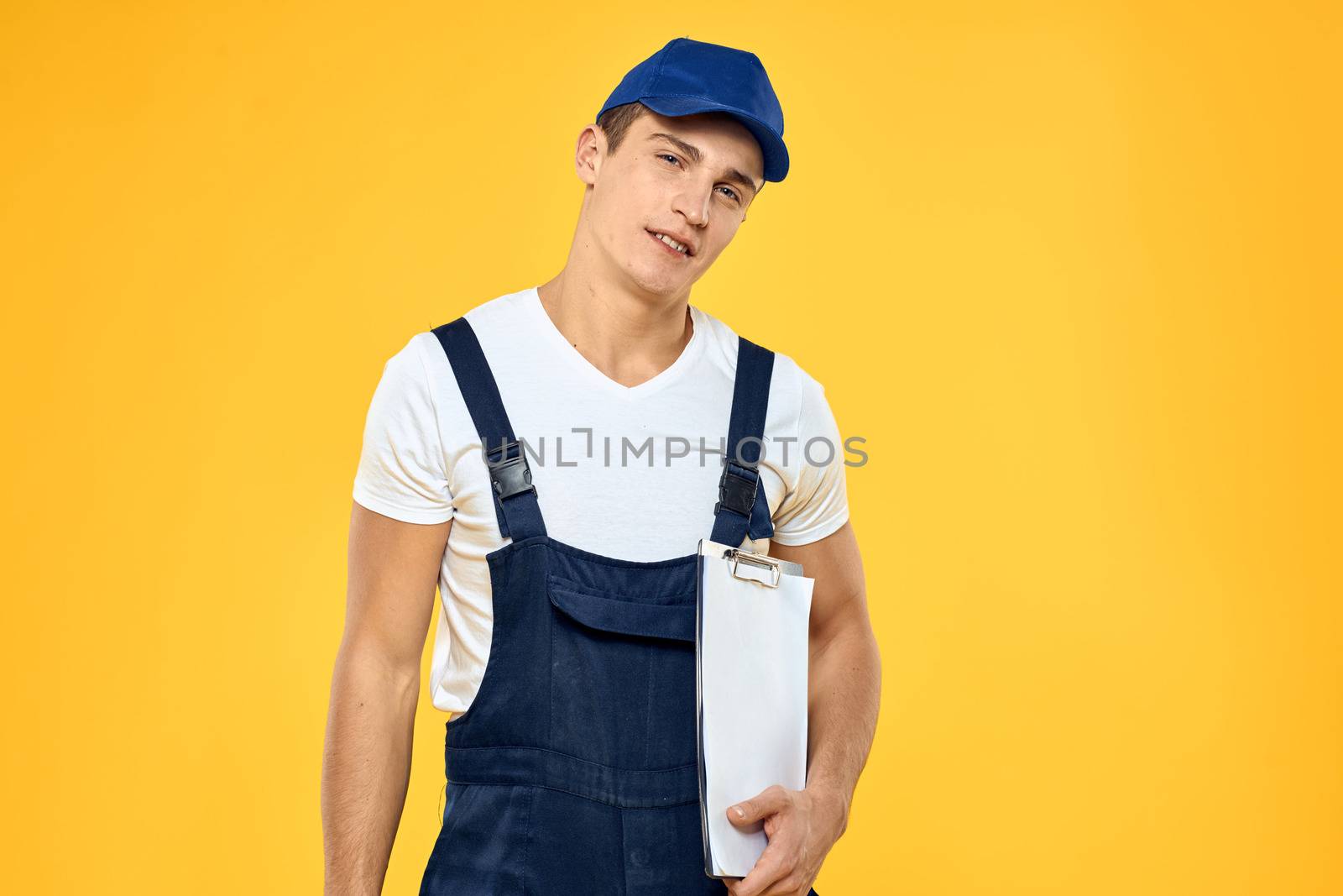 Man in working uniform documents rendering of services delivery service yellow background by SHOTPRIME