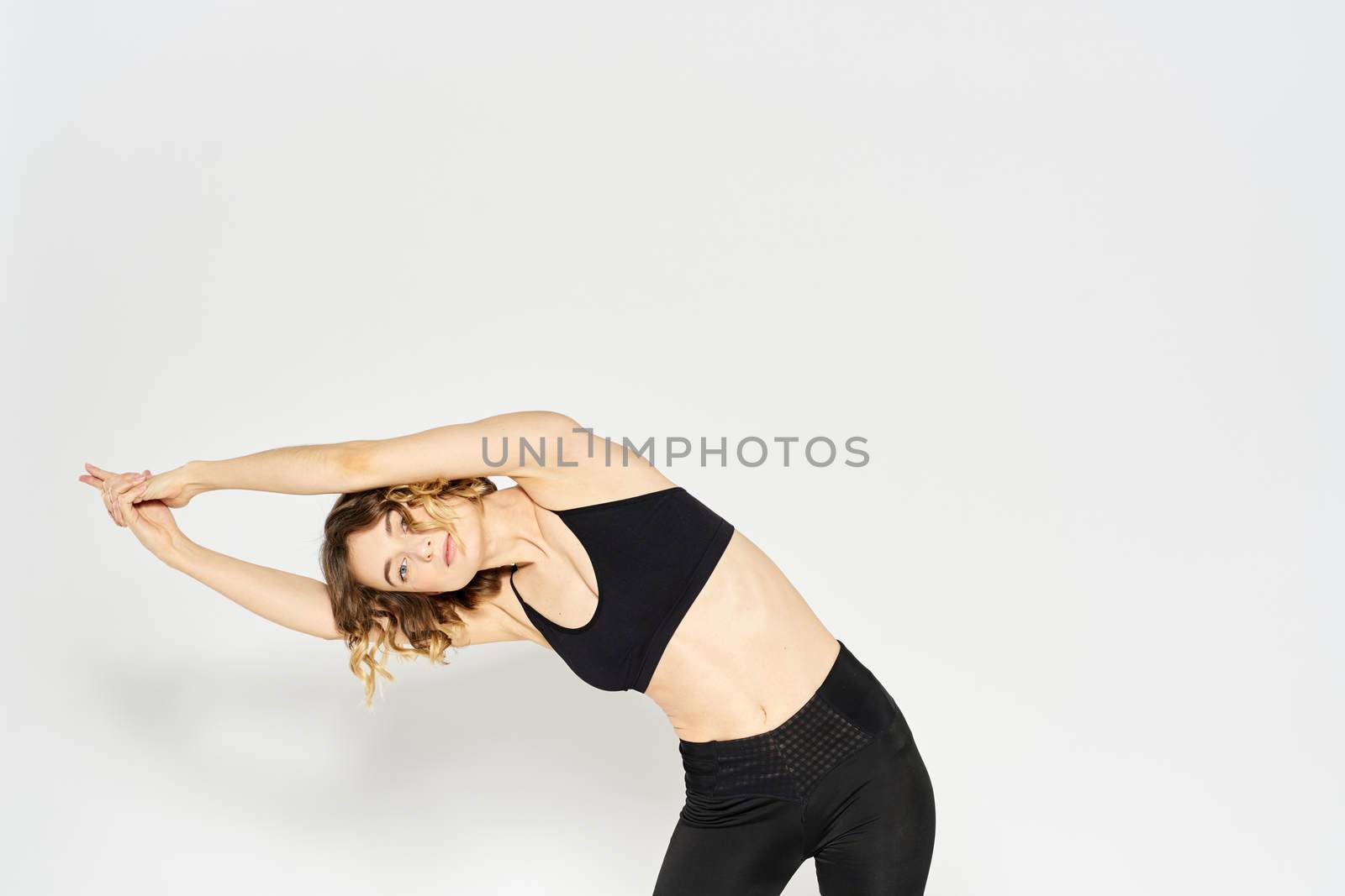 Slender woman in leggings on a light background doing fitness gymnastics exercises. High quality photo