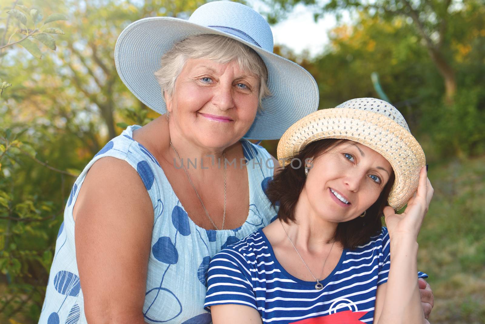 Happy daughter embracing her smiling mother at the garden by Nickstock