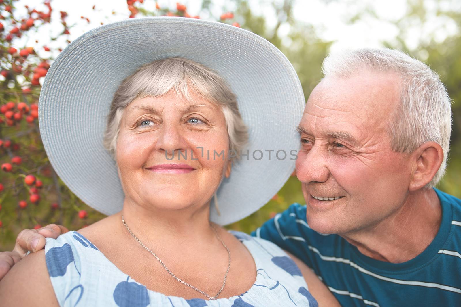 Authentic outdoor shot of aging couple having fun in the garden and blessed with love. by Nickstock