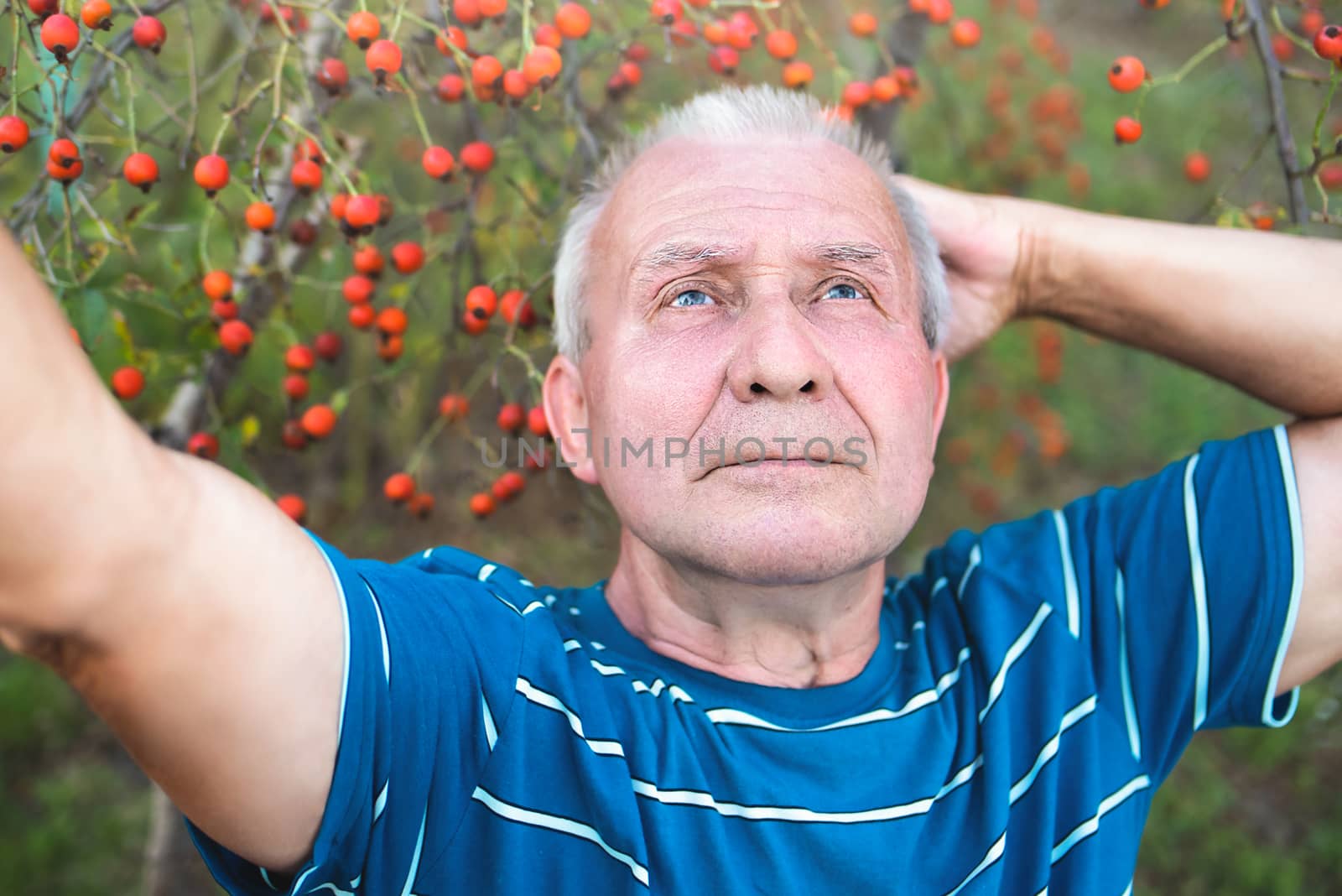 retired grandfather, makes selfie with a smartphone in the park and thinks about some important things