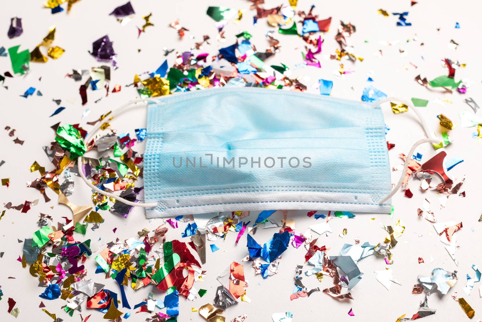Surgical face mask droped on flor with confetti after celebration new year 2021 party background stock image