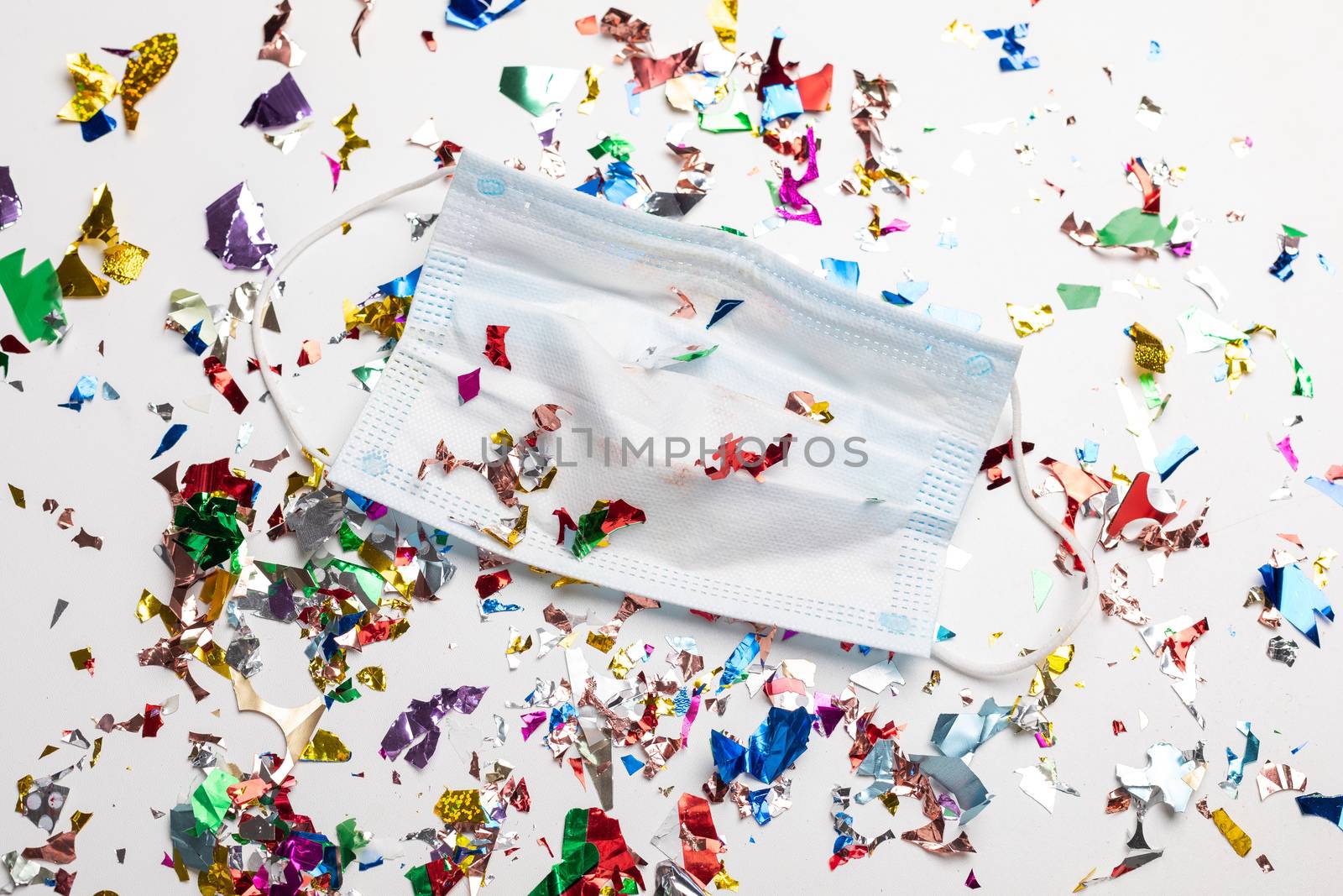 Facemask droped on flor with confetti after celebration new year 2021 party background stock image