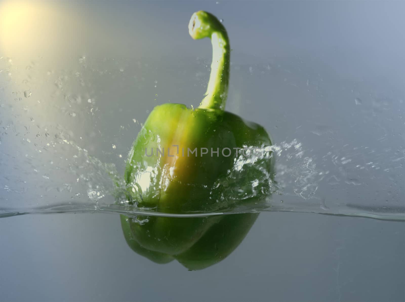 Vintage green bell peppers thrown into the water with a splash o by noppha80