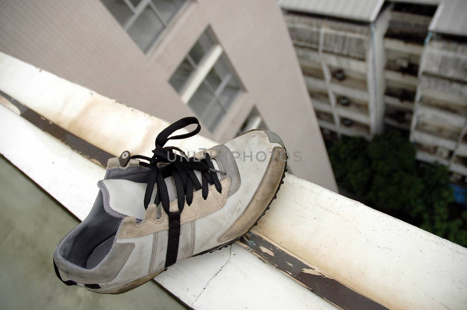 leftover shoe at the edge of a building roof by eyeofpaul