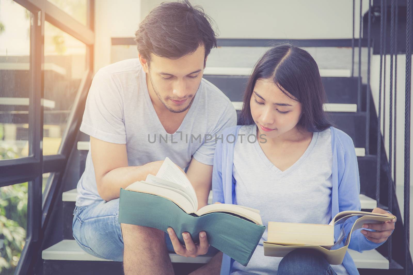 Couple asian handsome man and beautiful woman reading book and smile at home, boyfriend and girlfriend with activities together for leisure, education concept.