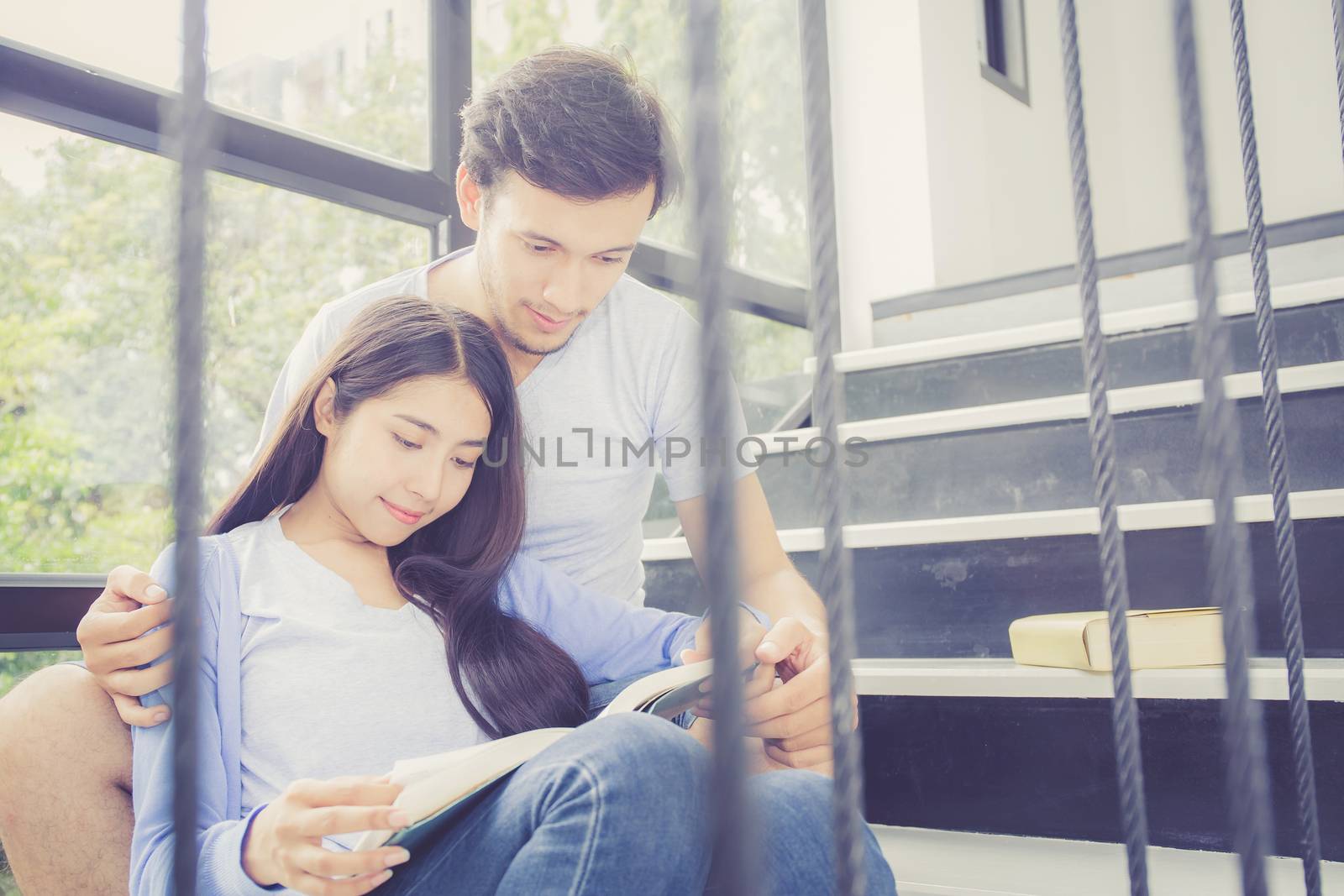 Couple asian handsome man and beautiful woman reading book and smile at home, boyfriend and girlfriend with activities together for leisure, education concept.