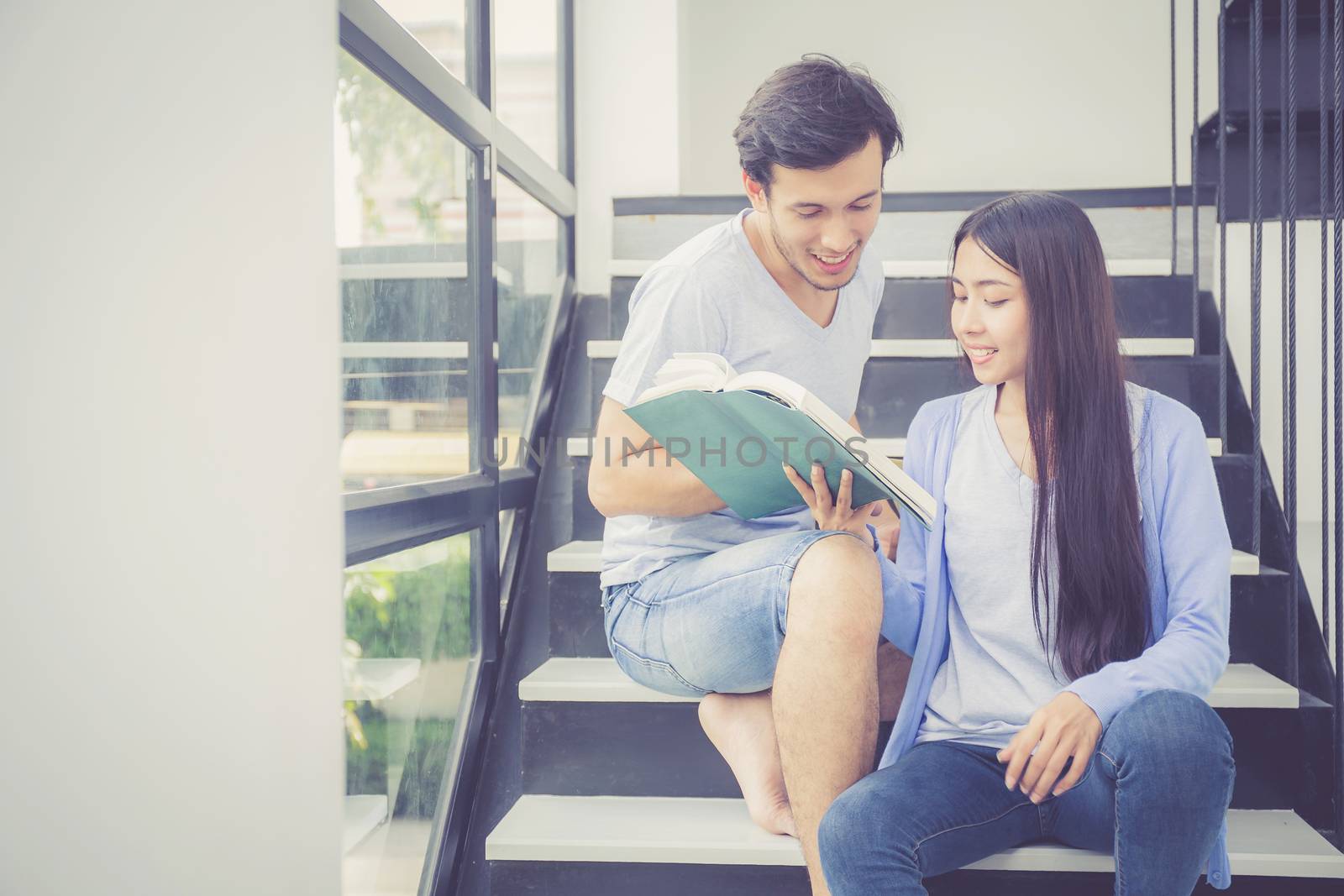 Couple asian handsome man and beautiful woman reading book and smile at home, boyfriend and girlfriend with activities together for leisure, education concept.