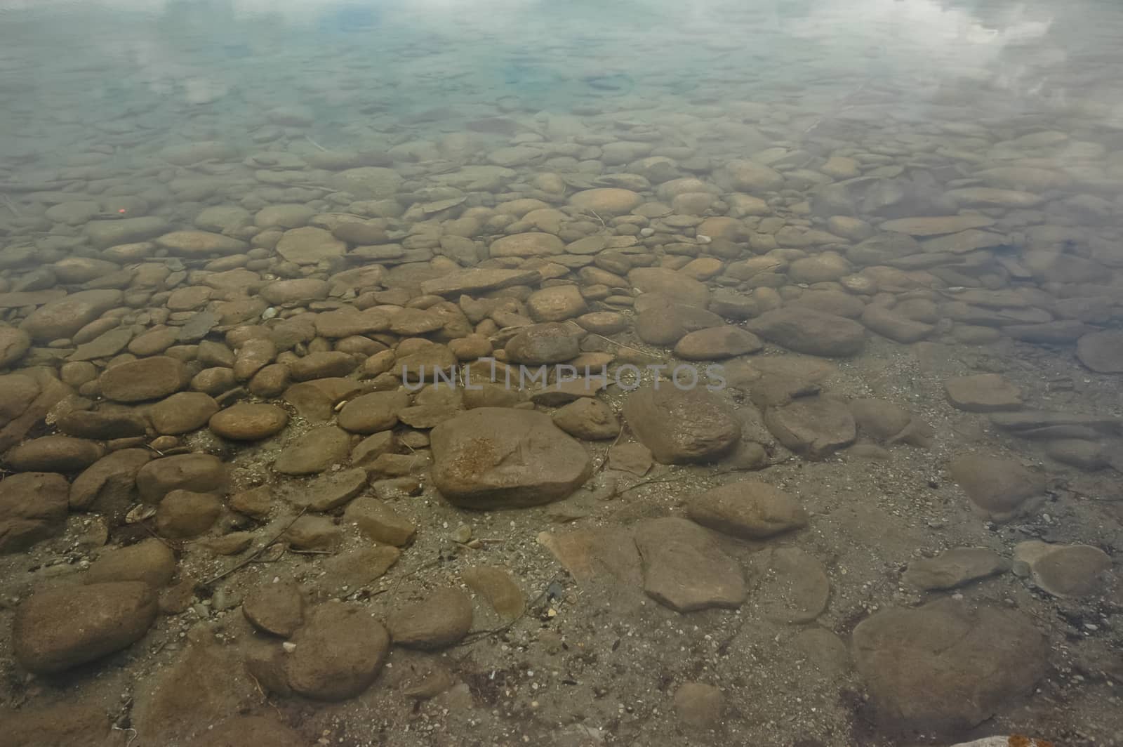 round stones under clear lake by eyeofpaul