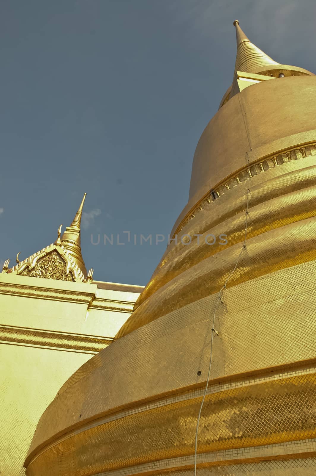 Golden stupa and blue sky in Bangkok Thailand by eyeofpaul