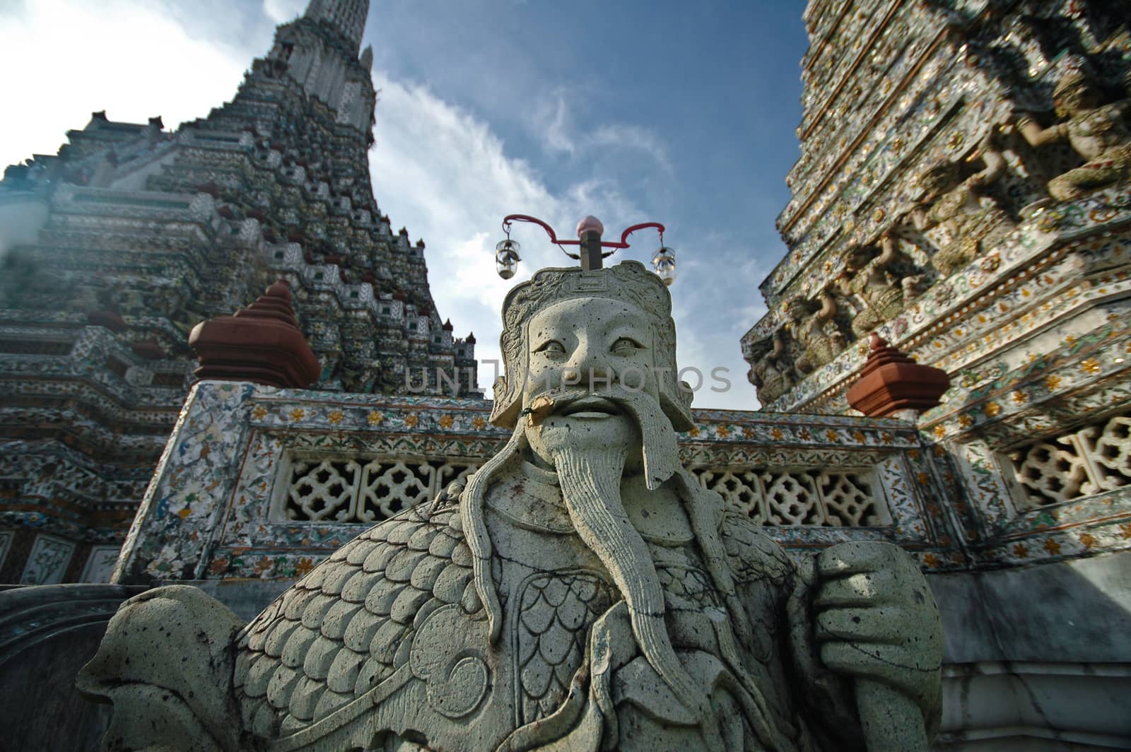 Old Chinese giant statue with Bangkok temple of dawn and blue sky