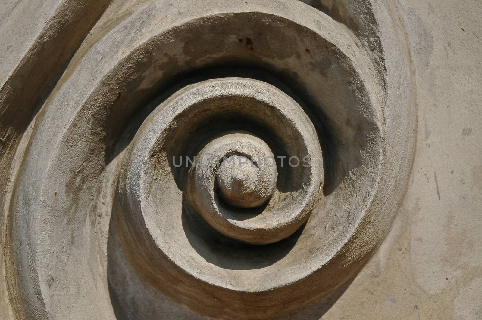 Abstract swirl circular art icon on concrete wall by eyeofpaul