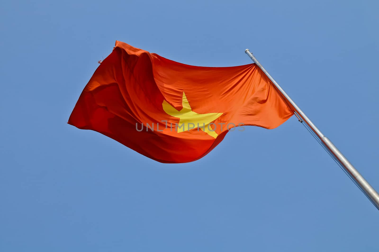 Vietnam national flag flying in blue sky by eyeofpaul