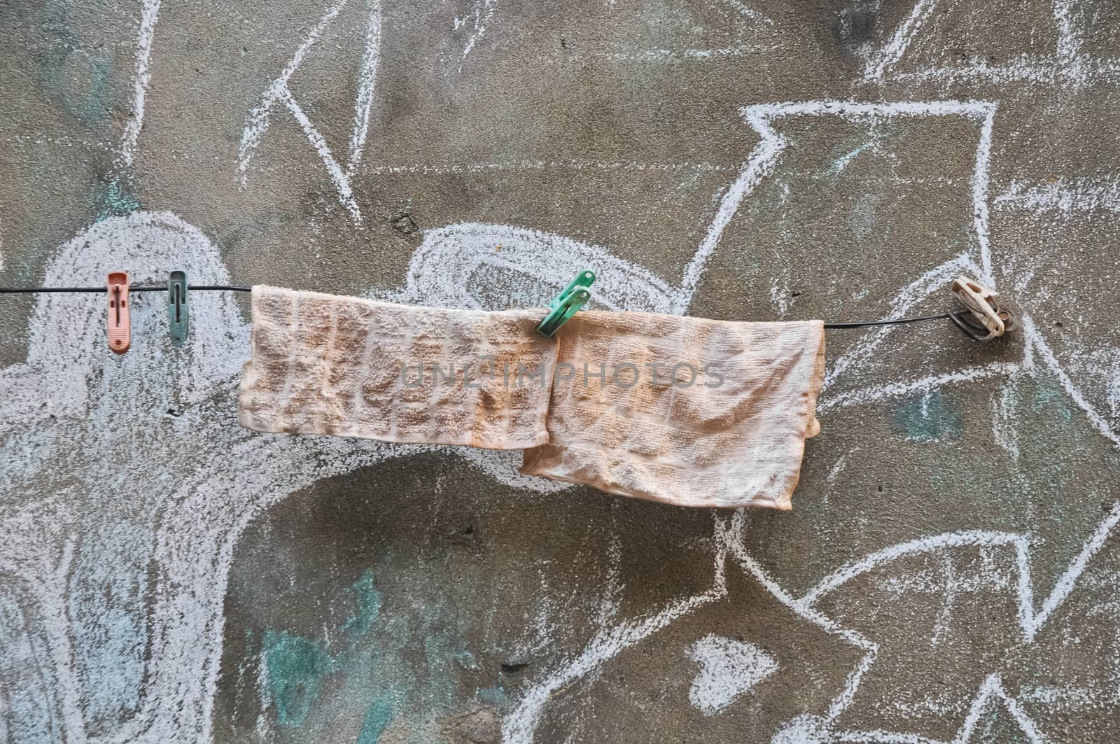 Rags hanging on a line of old wall