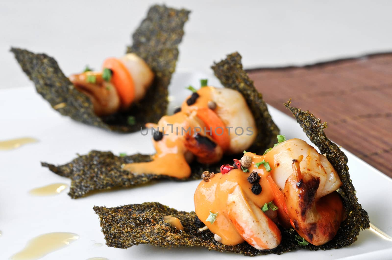 grilled scallops with sour sauce on crispy seaweed