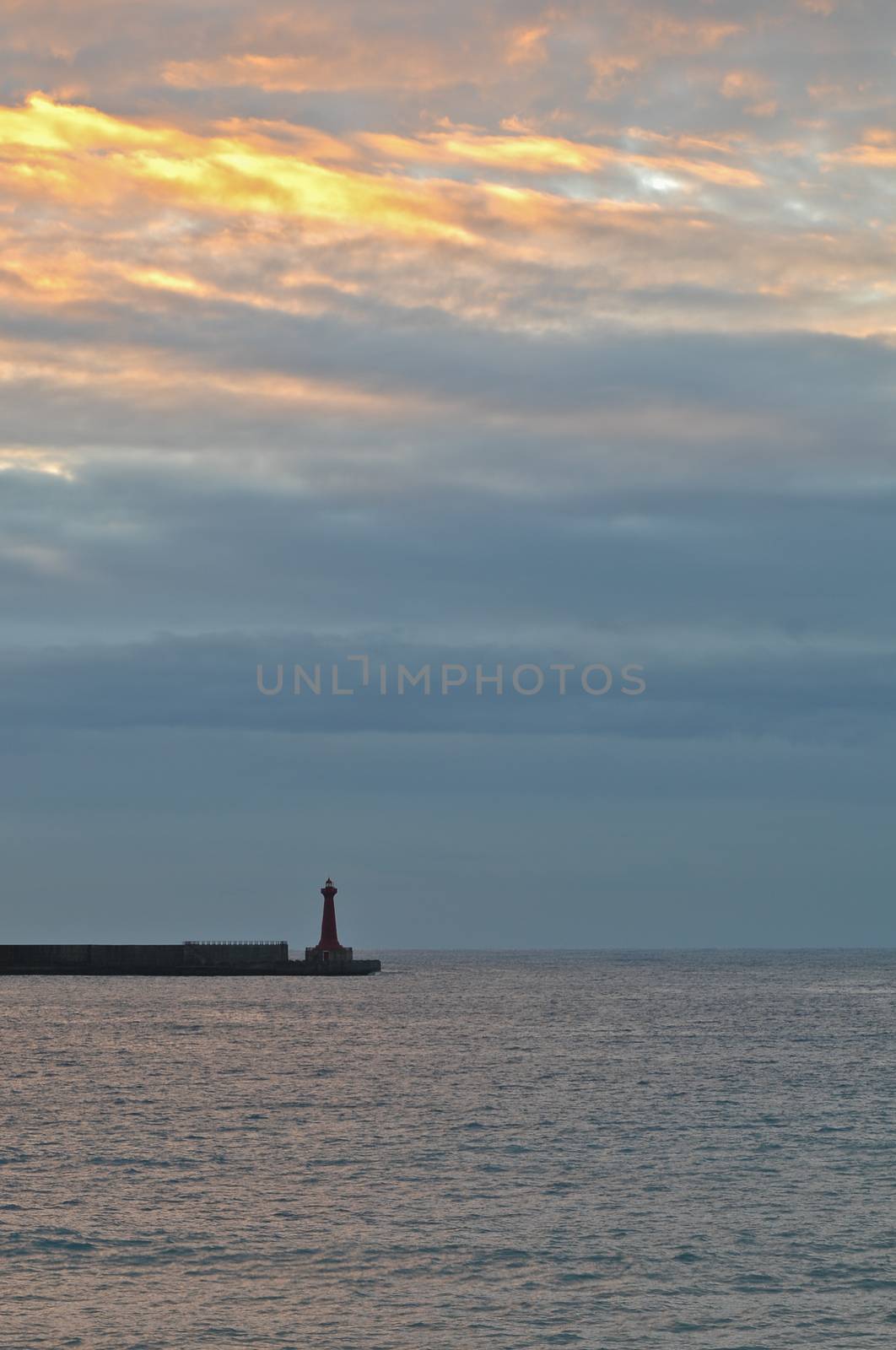 A lighthouse and the calm sea in early morning by eyeofpaul