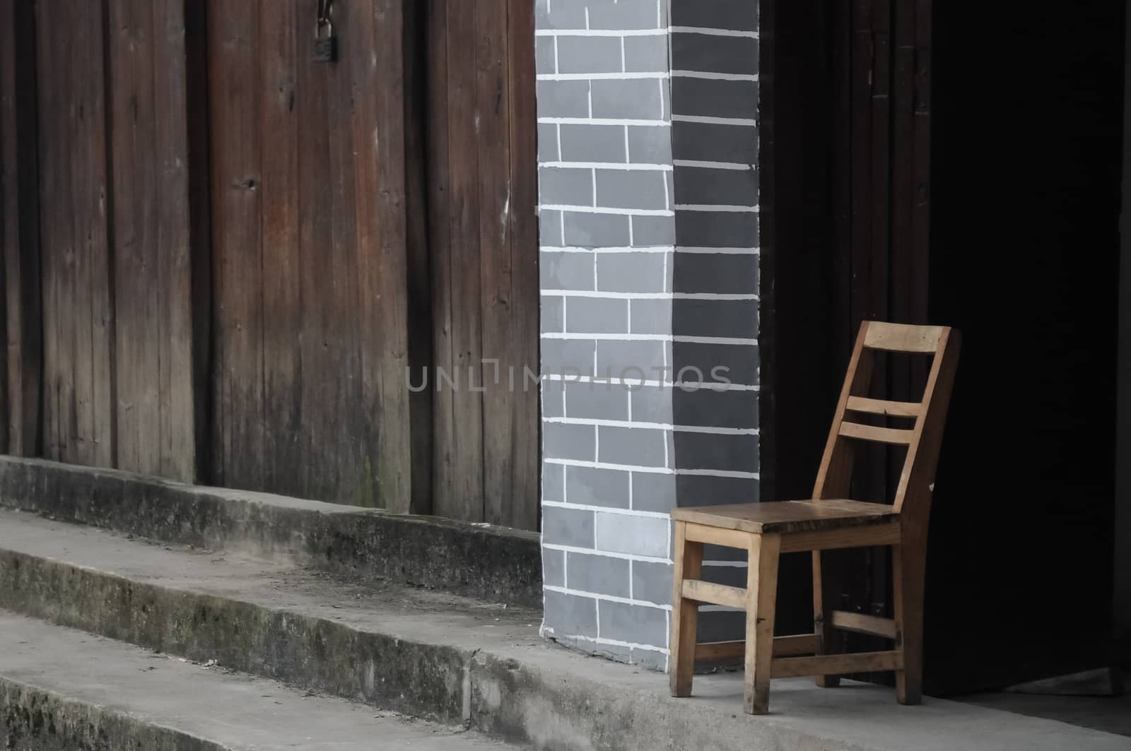 Old chair in front of Chinese vintage house by eyeofpaul