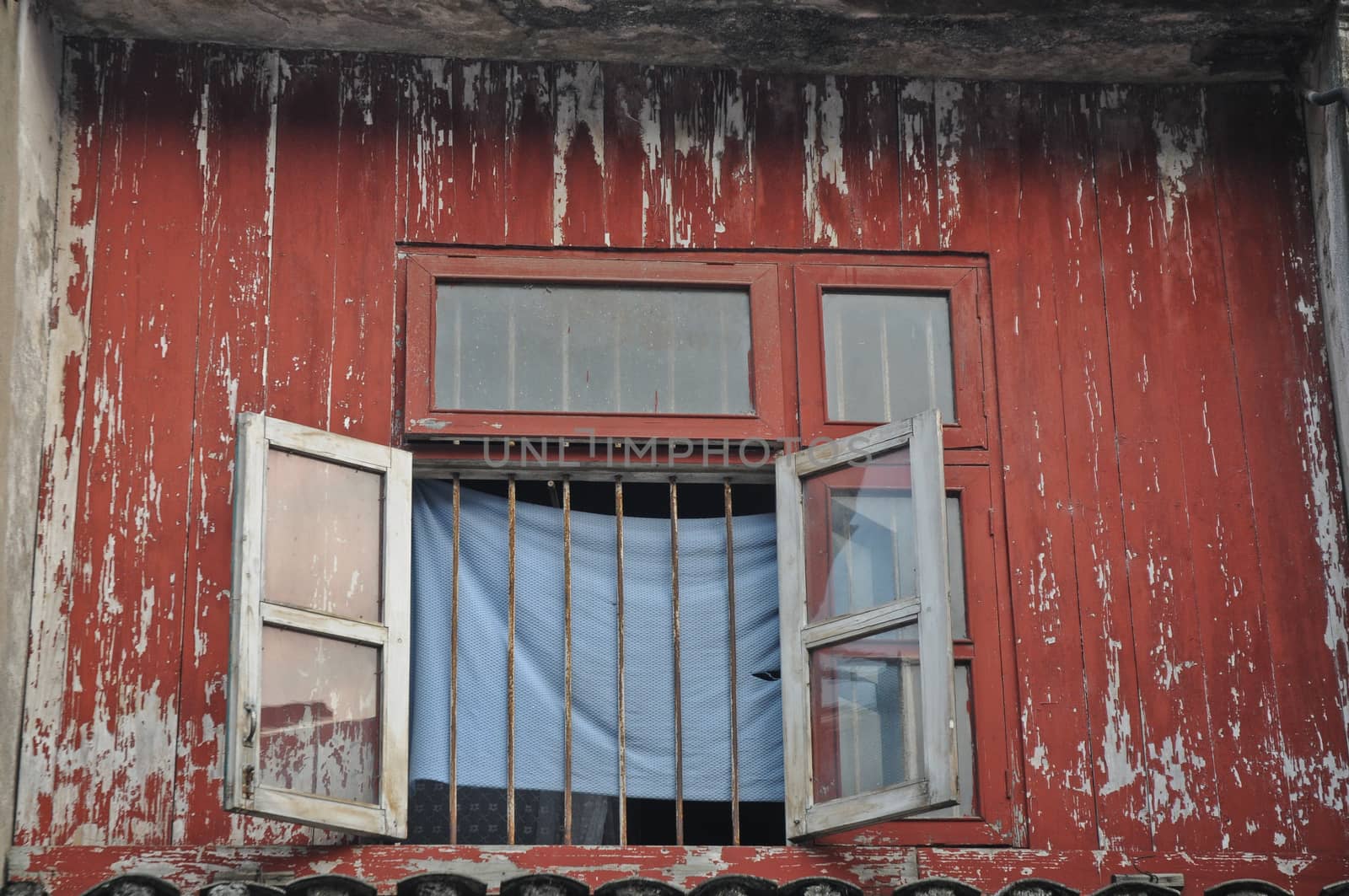 Opened window of old red wooden house in Vietnam