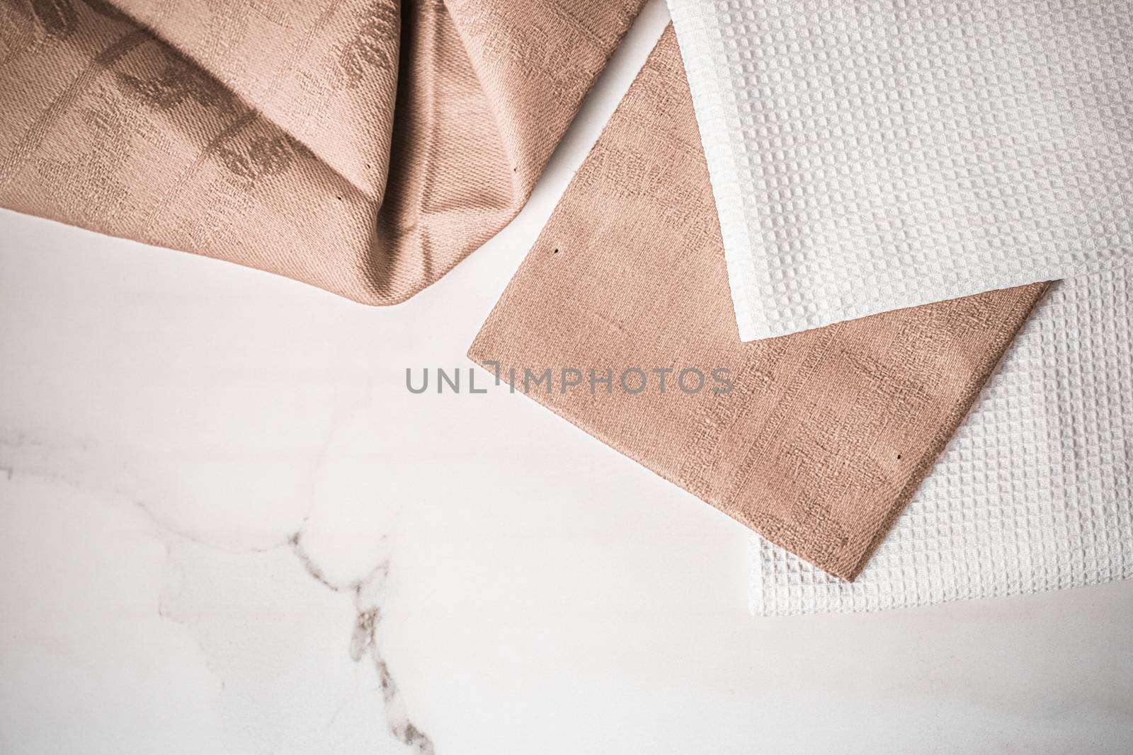 Tableware, material or cloth concept - Kitchen textile on chic white marble background, napkin and towel set, folded fabrics as food styling props for luxury home decor brand, interior design